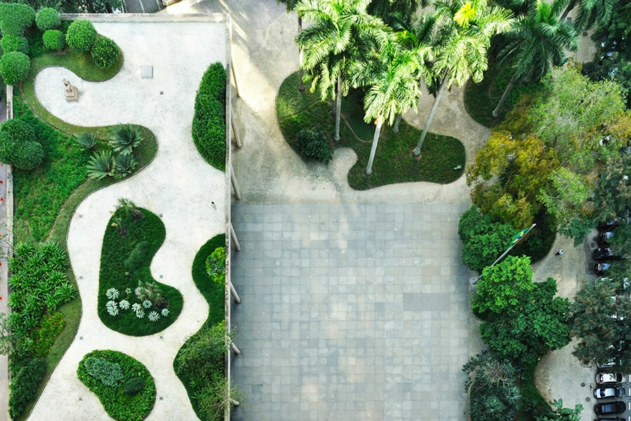 Photo aérienne d'un espace extérieur dessiné et conçut par Roberto Burle Marx, architecte paysagiste de renom. On y voit un toit végétalisé avec divers massifs aux formes arrondies et en contre-bas d'autres massifs aux formes similaires et au milieu, un espace en pavés