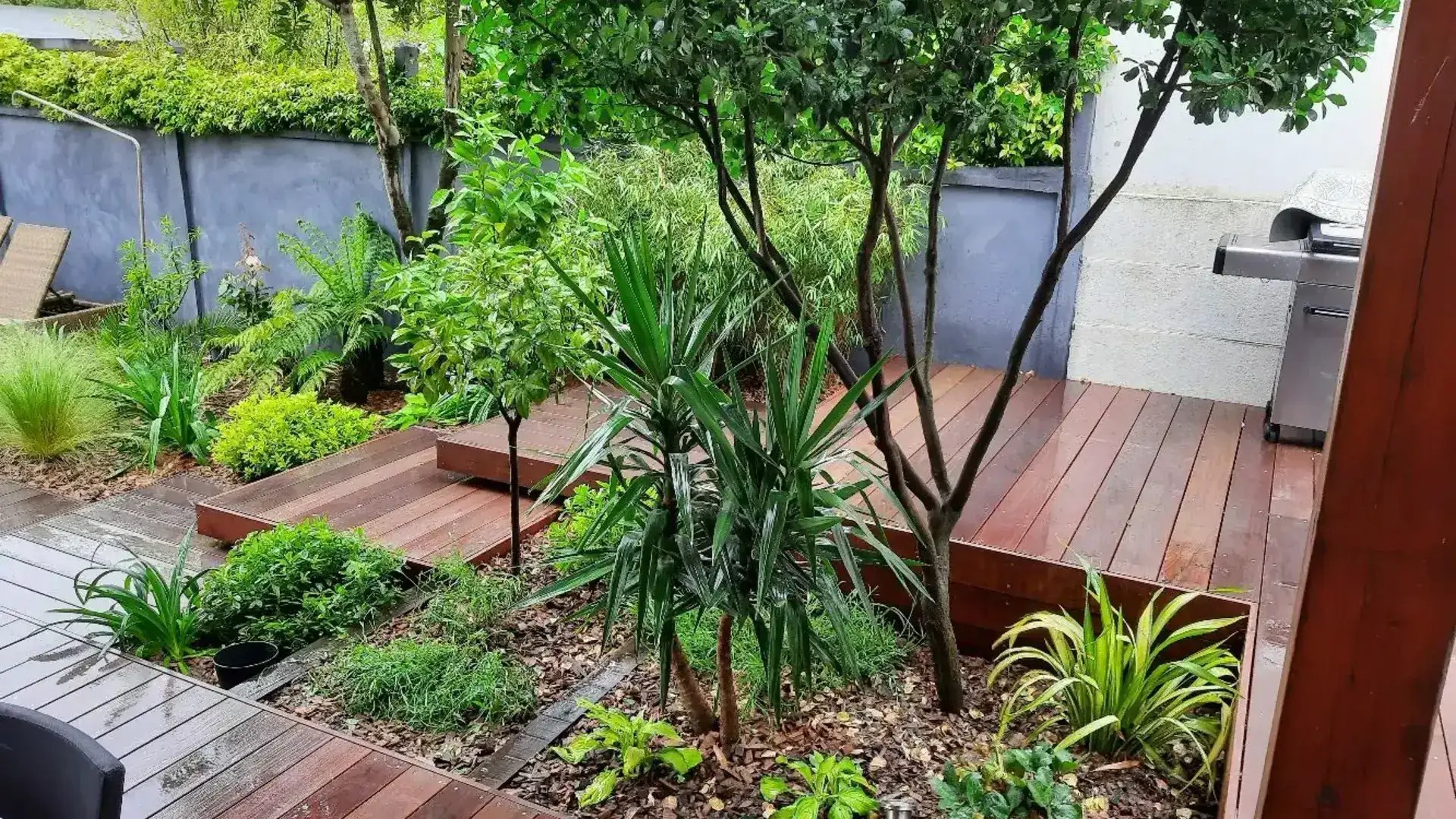 Aménagement d'une terrasse bois avec un escalier fixation invisible et divers massifs paysagers