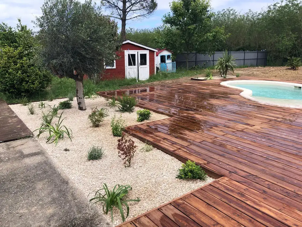 Aménagement de jardin avec terrasse bois et massifs paysagers